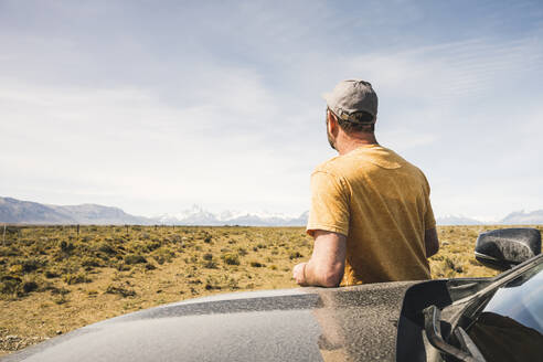 Rückansicht eines Mannes am Auto in abgelegener Landschaft in Patagonien, Argentinien - UUF20275