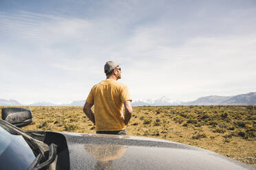 Rückansicht eines Mannes am Auto in abgelegener Landschaft in Patagonien, Argentinien - UUF20276