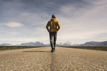 Mann geht auf einer Straße in abgelegener Landschaft in Patagonien, Argentinien - UUF20283