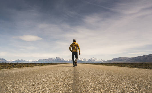 Mann geht auf einer Straße in abgelegener Landschaft in Patagonien, Argentinien - UUF20284