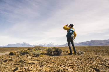Wanderer trinkt aus einer Flasche in abgelegener Landschaft in Patagonien, Argentinien - UUF20296