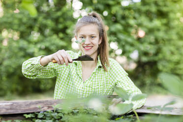 Young woman planting seedlings in urban garden - SGF02607