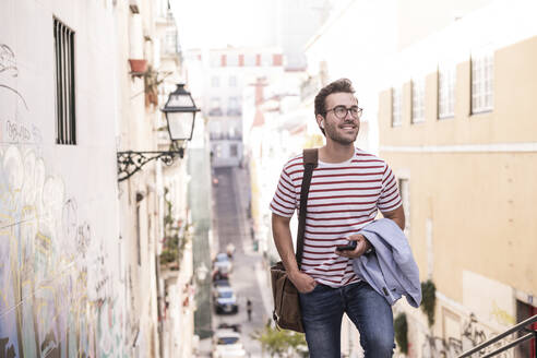 Junger Mann beim Spaziergang in der Stadt, Lissabon, Portugal - UUF20352