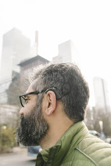 Man with cochlear implant in front of skycrapers, Frankfurt, Germany - AHSF02462