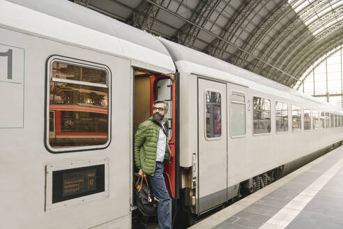 Mann steigt aus einem Zug - AHSF02472