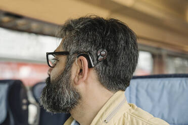 Profile of a man with cochlear implant in a train - AHSF02488