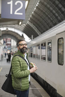 Man with sandwich at the train station - AHSF02490