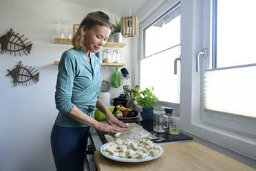 Woman preparing gnocchi in kitchen - ECPF00899