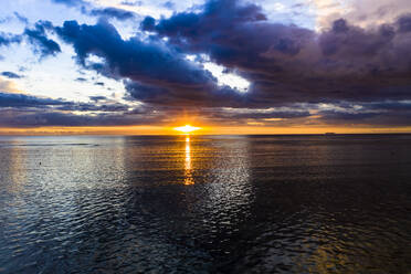 Mauritius, Helicopter view of dark storm clouds over Indian Ocean at sunset - AMF08054