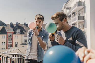 Gruppe von Freunden spielt mit Luftballons auf einem Balkon - KNSF08047