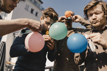 Gruppe von Freunden spielt mit Luftballons auf einem Balkon - KNSF08049