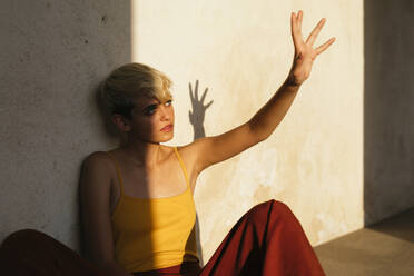 Portrait of blond female teenager and her shadow on the wall - TCEF00592