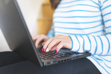 Woman using laptop, typing on keyboard - WPEF02864