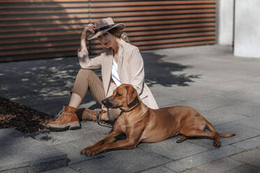 Fashionable woman with her dog in the city - OGF00379