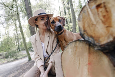 Porträt einer eleganten Frau und ihres Hundes in der Natur - OGF00384