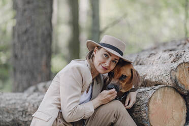 Porträt einer eleganten Frau und ihres Hundes im Wald - OGF00385