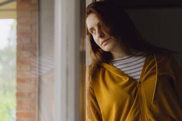 Portrait of redheaded woman looking out of window - AFVF06214