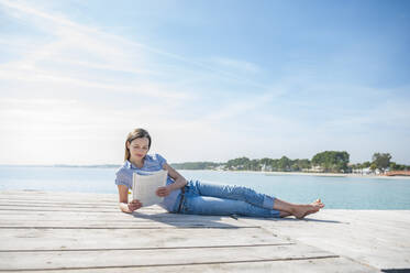 Frau auf Bootssteg beim Lesen einer Zeitschrift, Mallorca, Spanien - DIGF10333