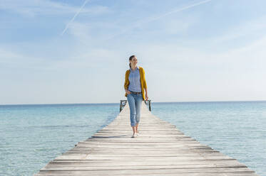 Glückliche Frau beim Spaziergang auf dem Bootssteg, Mallorca, Spanien - DIGF10336