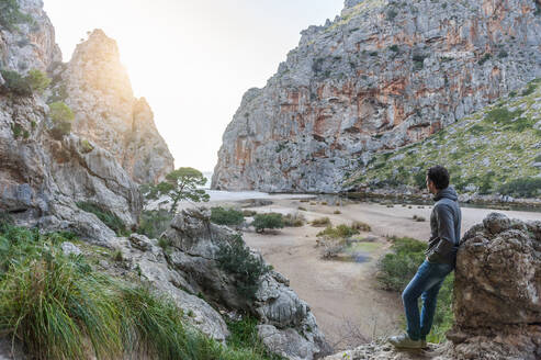 Mann genießt die Natur und blickt auf das Meer, Mallorca, Spanien - DIGF10359