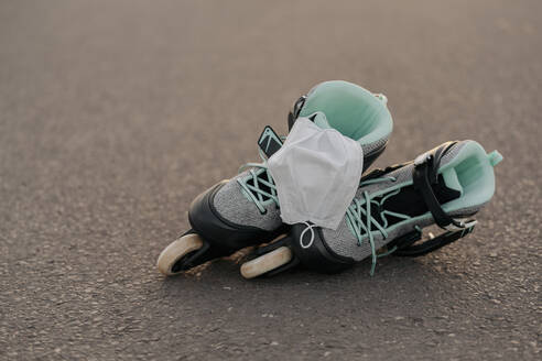 Nahaufnahme einer Gesichtsmaske auf Inline-Skates in einem Skateboard-Park - STDF00236