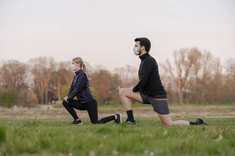 Young couple exercising at park during coronavirus pandemic stock photo