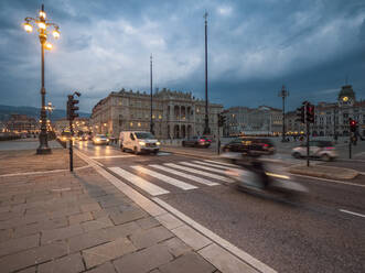 Italien, Provinz Triest, Triest, Verkehr auf der Piazza dellUnita dItalia in der Abenddämmerung - LAF02467