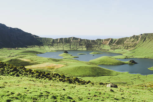 Landschaftlicher Blick auf einen See inmitten von Bergen bei klarem Himmel an einem sonnigen Tag, Corvo, Azoren, Portugal - FVSF00233