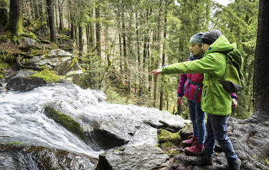 Junge und Mädchen betrachten einen Wasserfall im Nordschwarzwald - DIKF00483