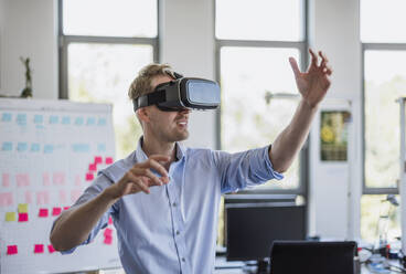 Man wearing VR glasses in office - DIGF10387