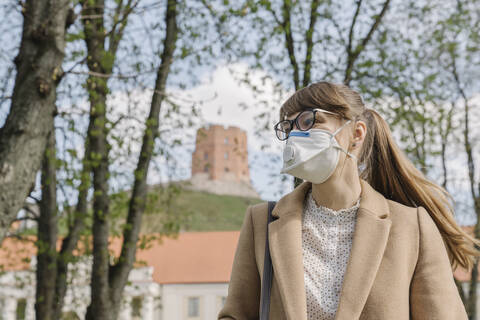 Woman wearing FFP2 mask looking sideways in the city stock photo