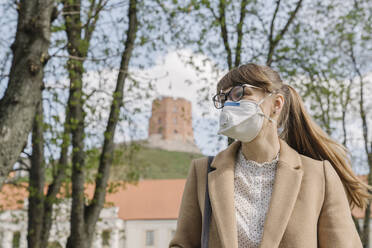 Woman wearing FFP2 mask looking sideways in the city - AHSF02513