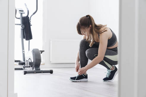 Woman preparing for a workout at home - AHSF02517