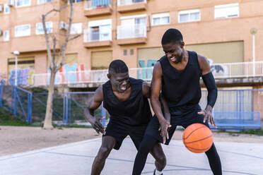 Basketball players playing basketball on court outdoors - EGAF00018