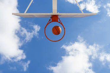 Basketball and hoop, blue sky, upward view - EGAF00029