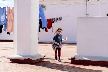 Porträt eines kleinen Mädchens, das auf einem Dach läuft - EGAF00036