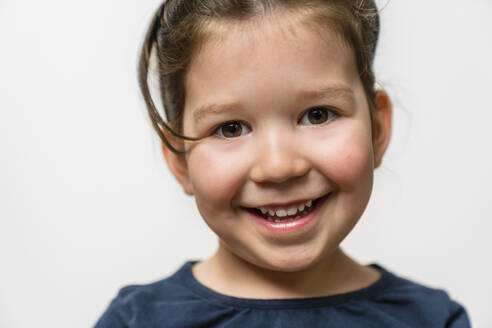 Portrait of happy girl against white background - MGIF00922