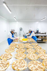 Frauen bei der Zubereitung von Pizzen in einer Pizzafirma - XLGF00130