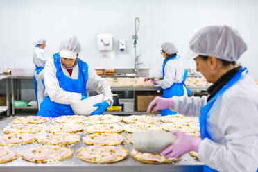 Frauen bei der Zubereitung von Pizzen in einer Pizzafirma - XLGF00132