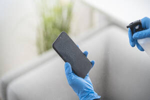 Close-up of woman disinfecting cell phone - SNF00028
