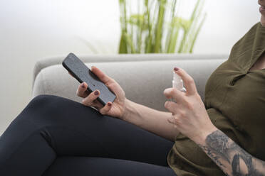 Close-up of woman disinfecting cell phone - SNF00030