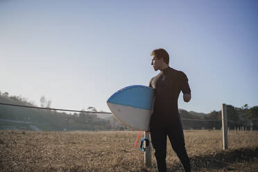 Behinderter Surfer mit Surfbrett auf dem Weg zum Strand - SNF00073
