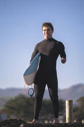 Behinderter Surfer mit Surfbrett am Strand - SNF00091