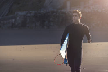 Behinderter Surfer mit Surfbrett am Strand - SNF00092