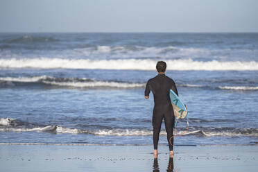 Behinderter Surfer mit Surfbrett am Strand - SNF00093