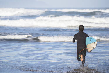 Behinderter Surfer mit Surfbrett am Strand - SNF00094