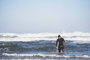 Behinderter Surfer mit Surfbrett am Strand - SNF00095