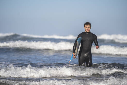 Handicapped surfer with surfboard at beach - SNF00096