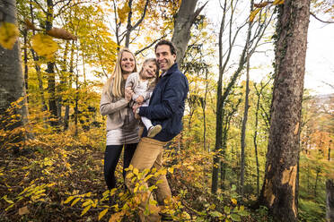 Portrait of smiling family standing in forest during autumn - WFF00406