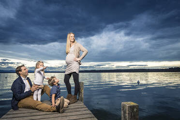 Glückliche Familie in voller Länge auf dem Steg am Starnberger See vor bewölktem Himmel - WFF00408